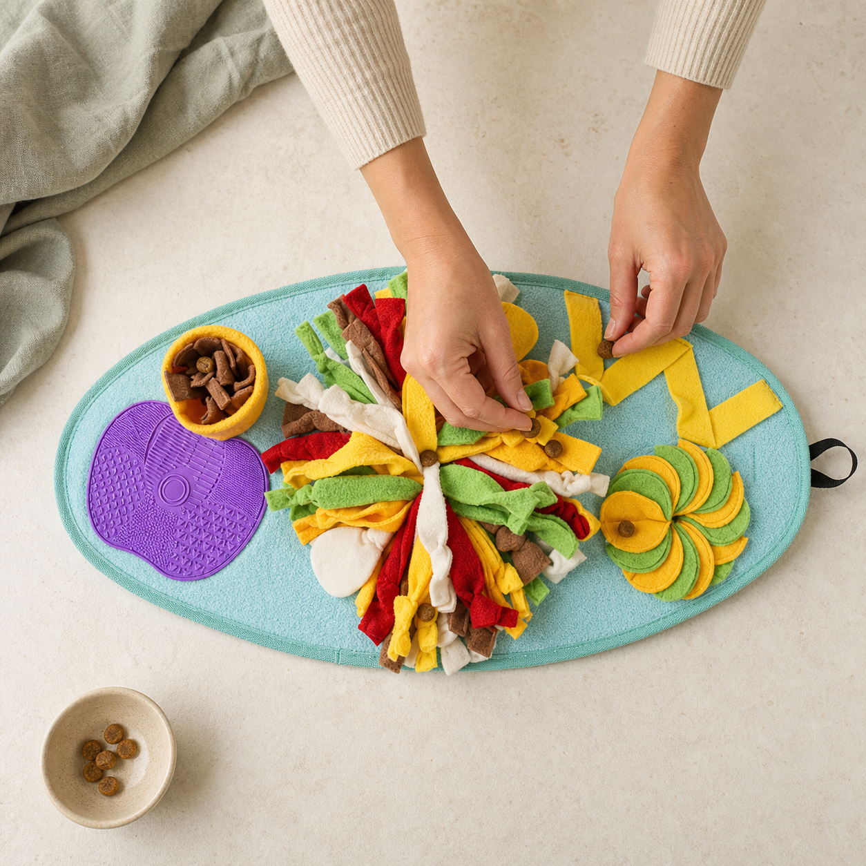 Hands hiding treats in the snuffle mat activity zones